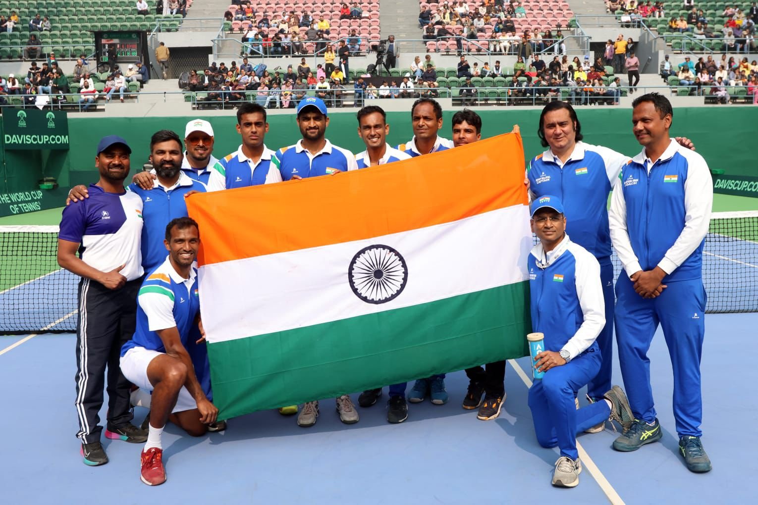 Indian Davis Cup tennis team with sports physiotherapist holding the national flag on the court
